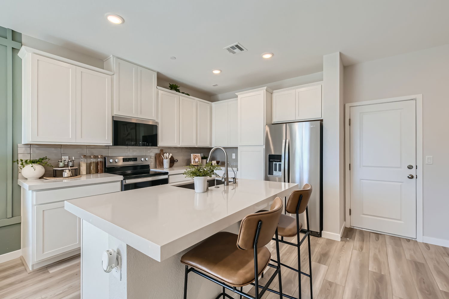 A kitchen with white cabinets.