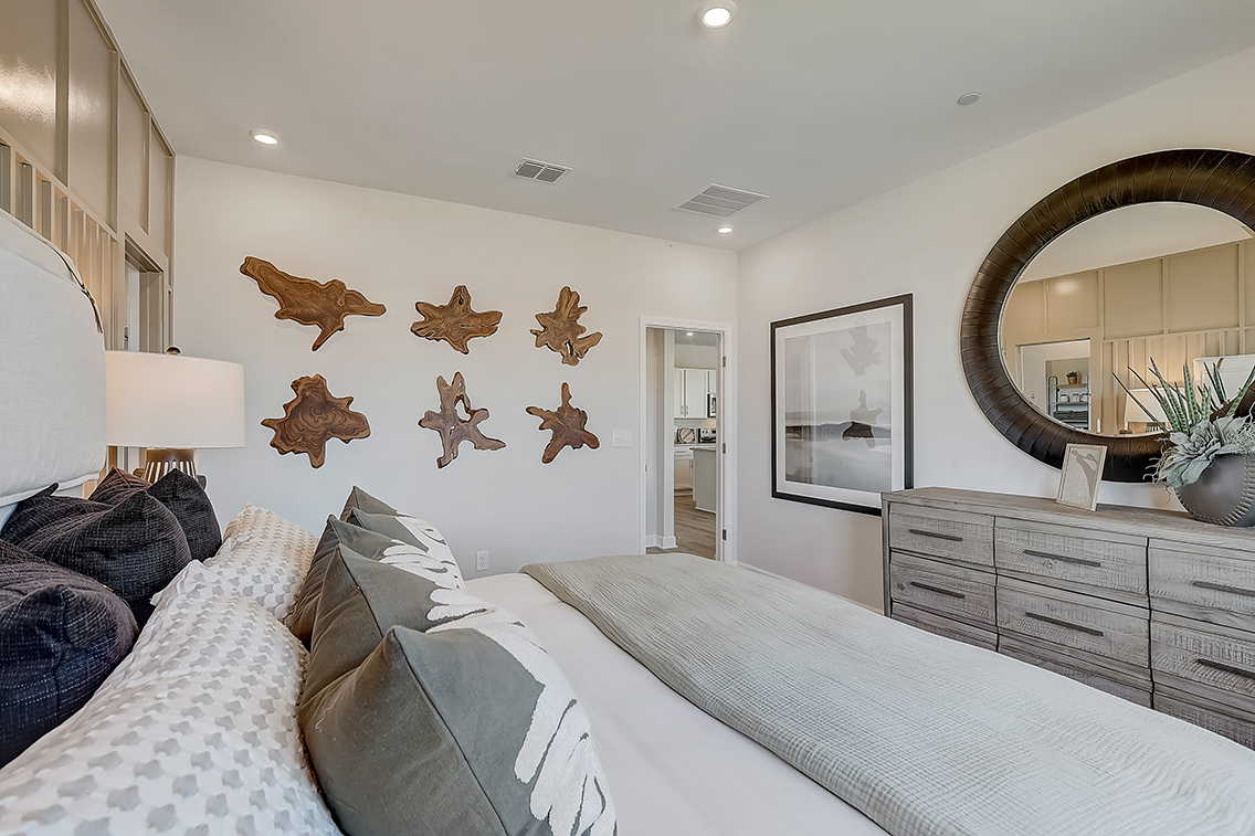 A bedroom with a large mirror.