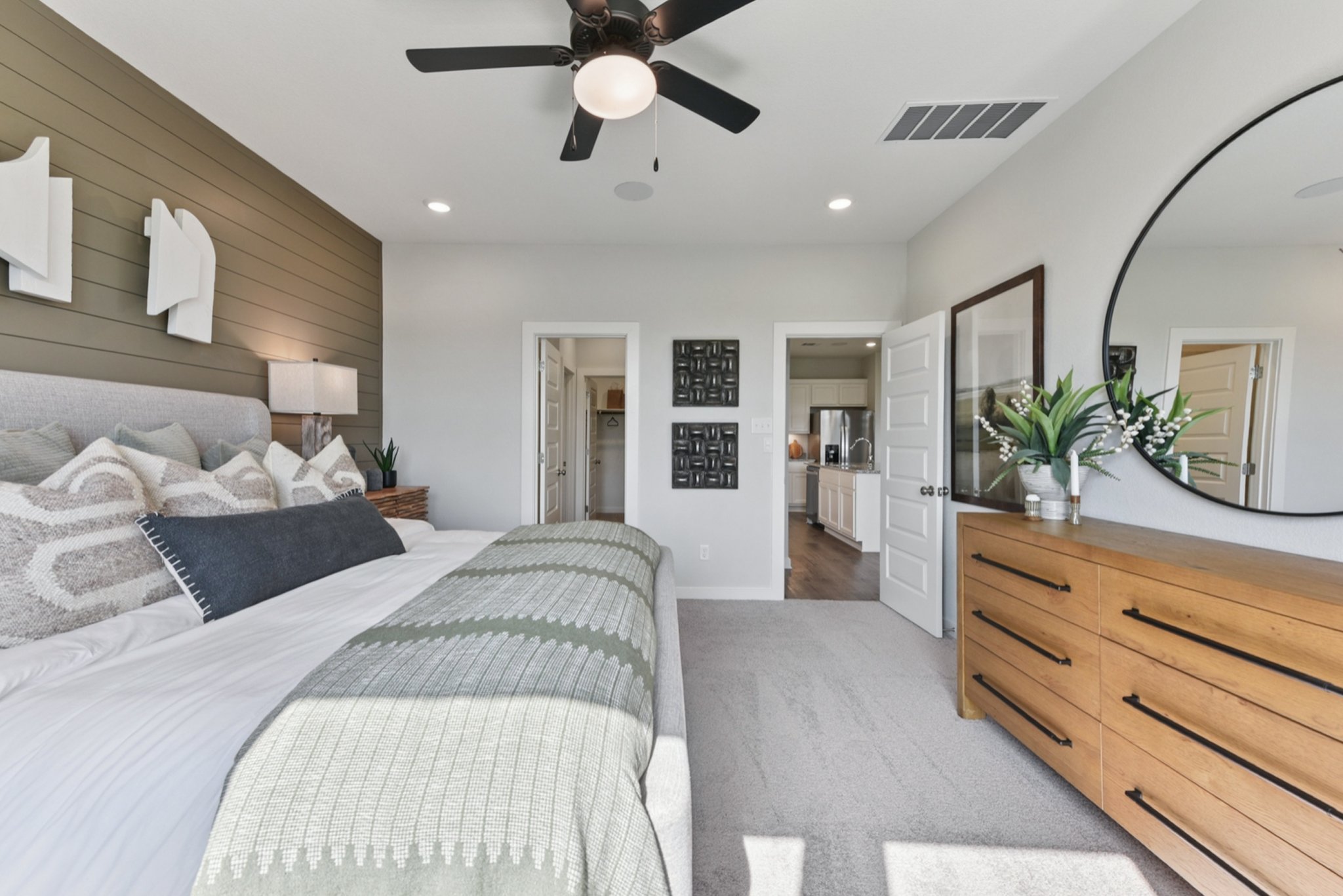 A bedroom with a bed and a fan.