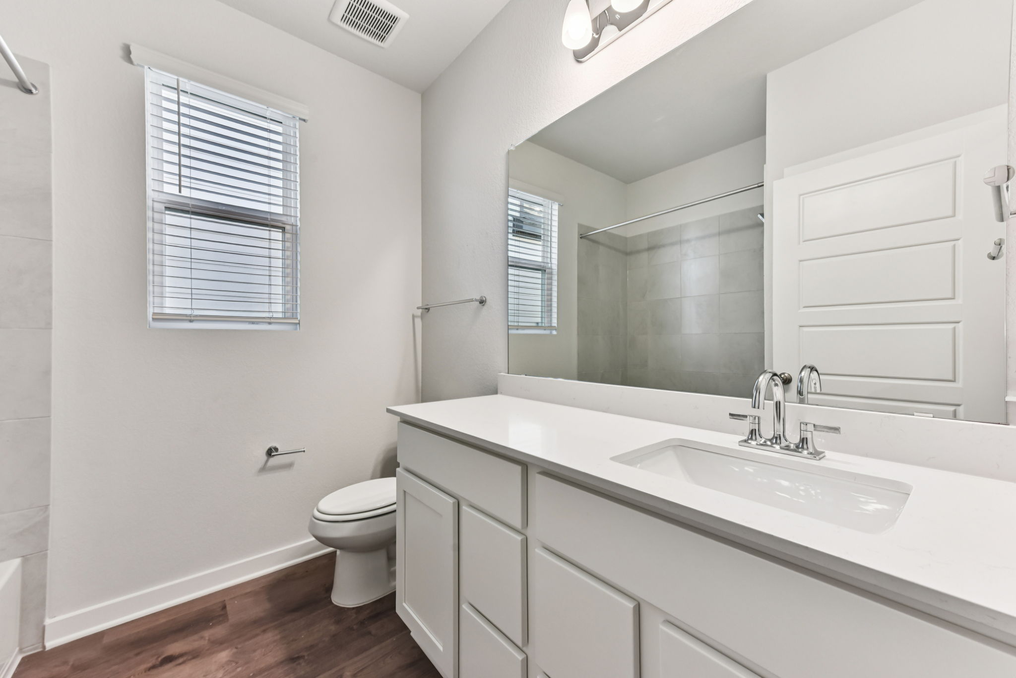 A bathroom with a large mirror.