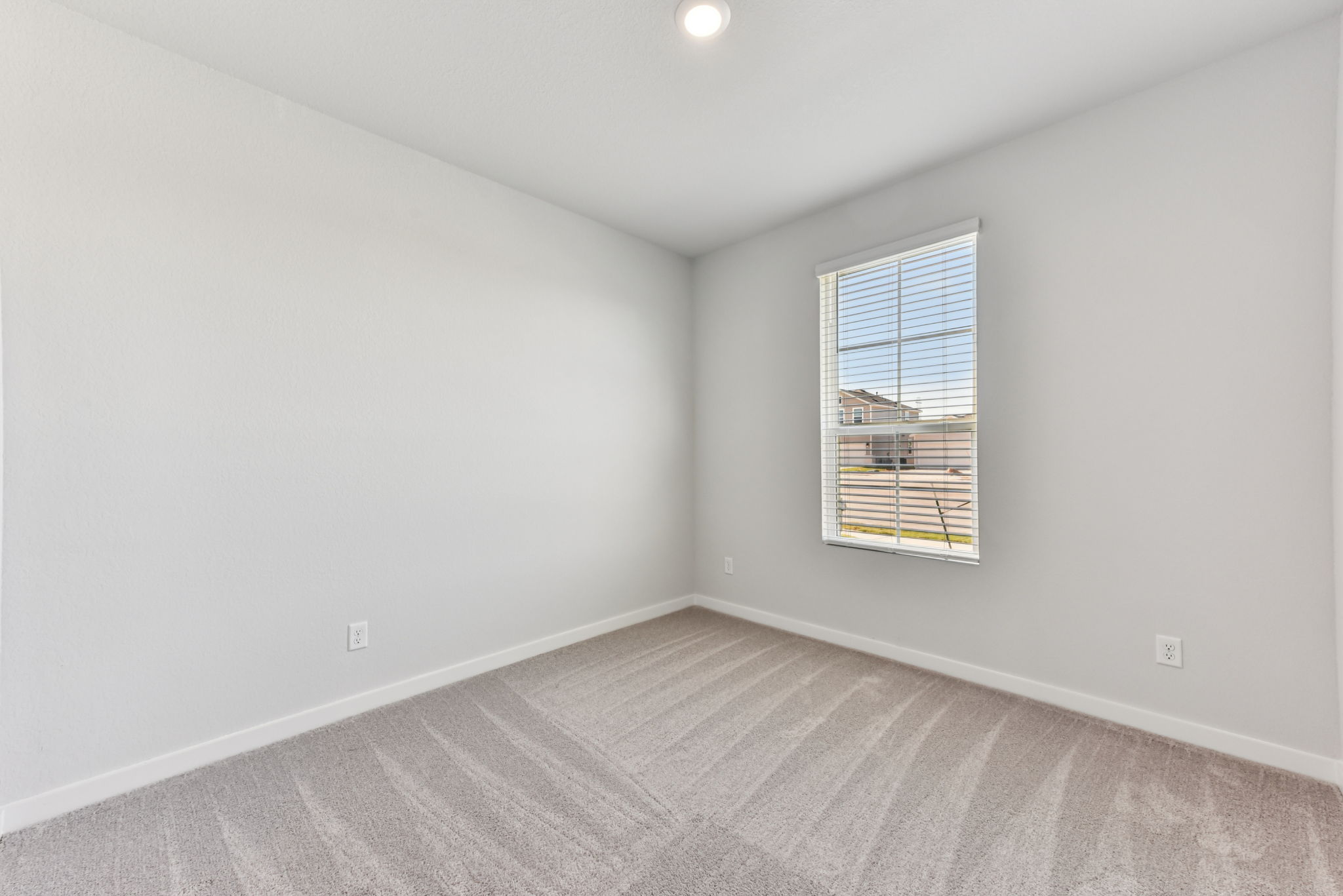 A room with a window and a carpet.