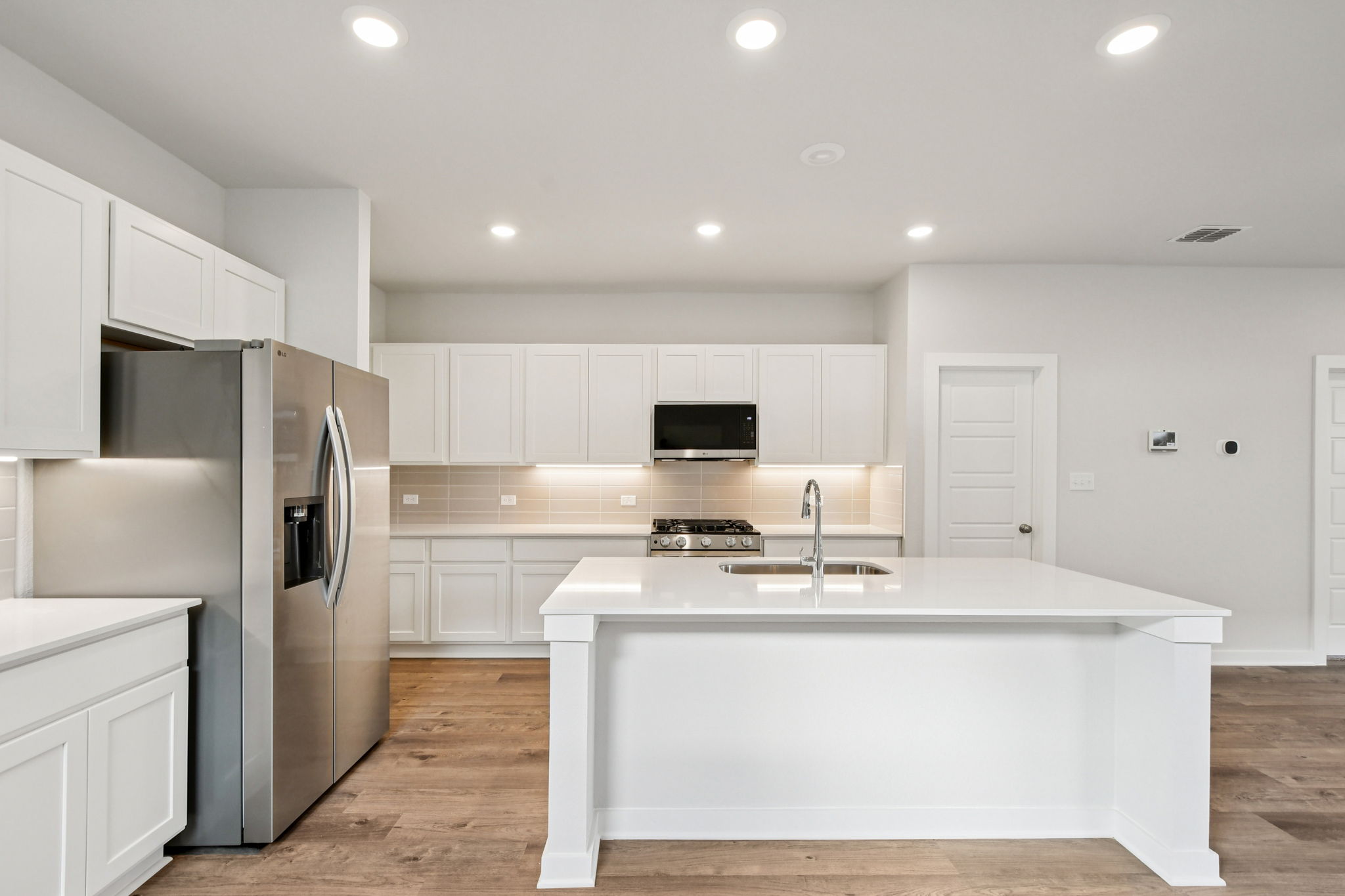 A kitchen with white cabinets.