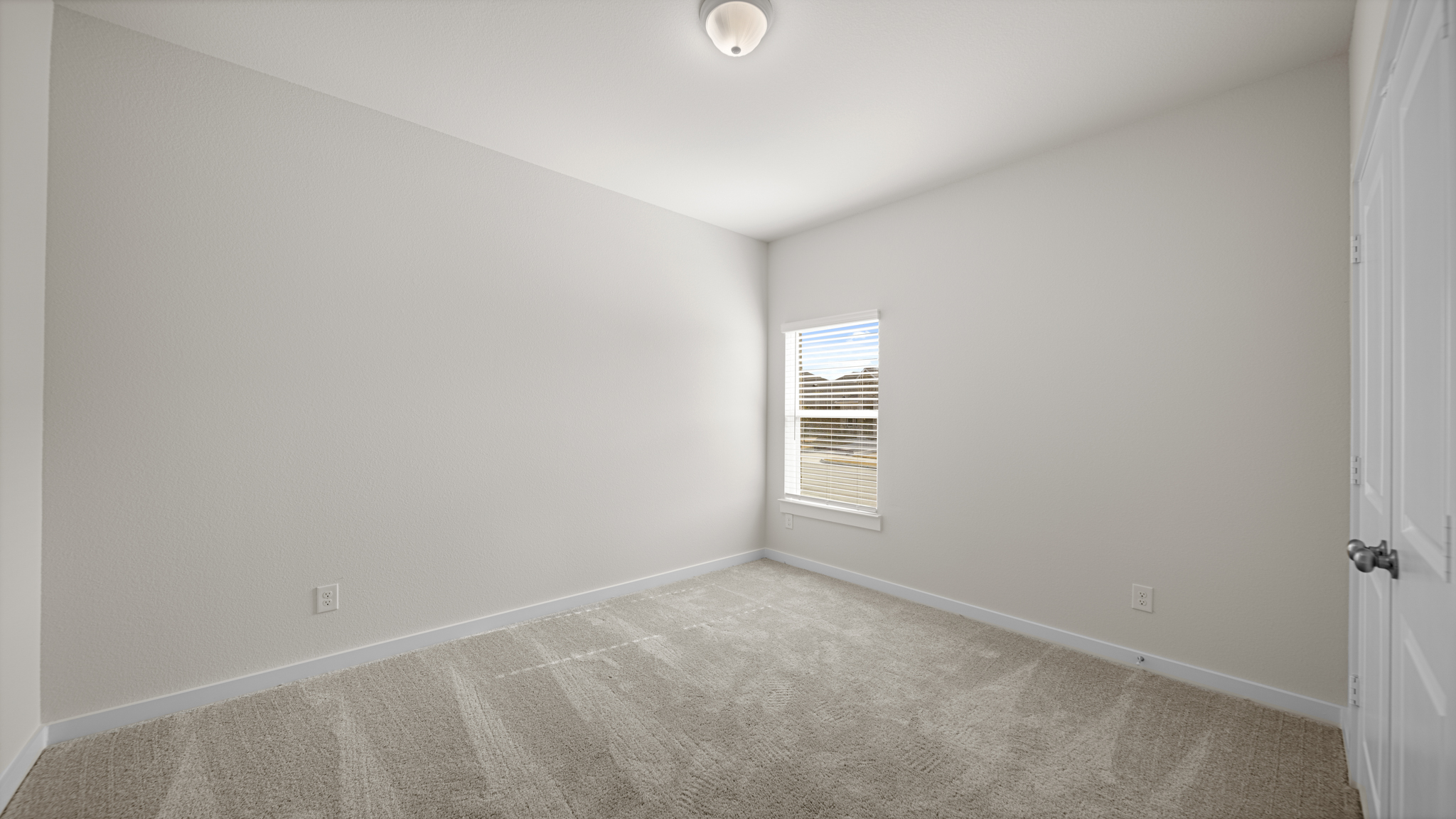 A room with a carpet and a window.