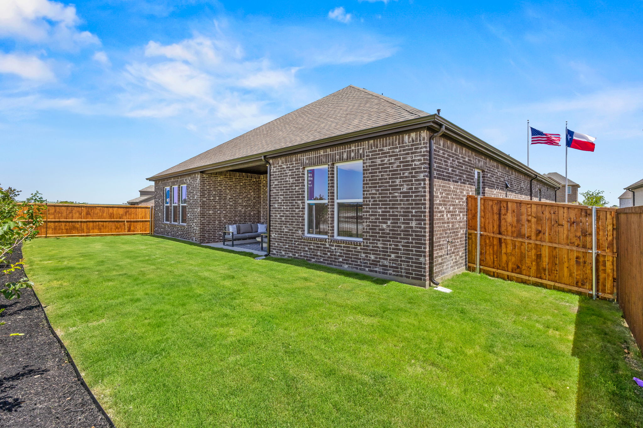 A brick house with flags on the side.