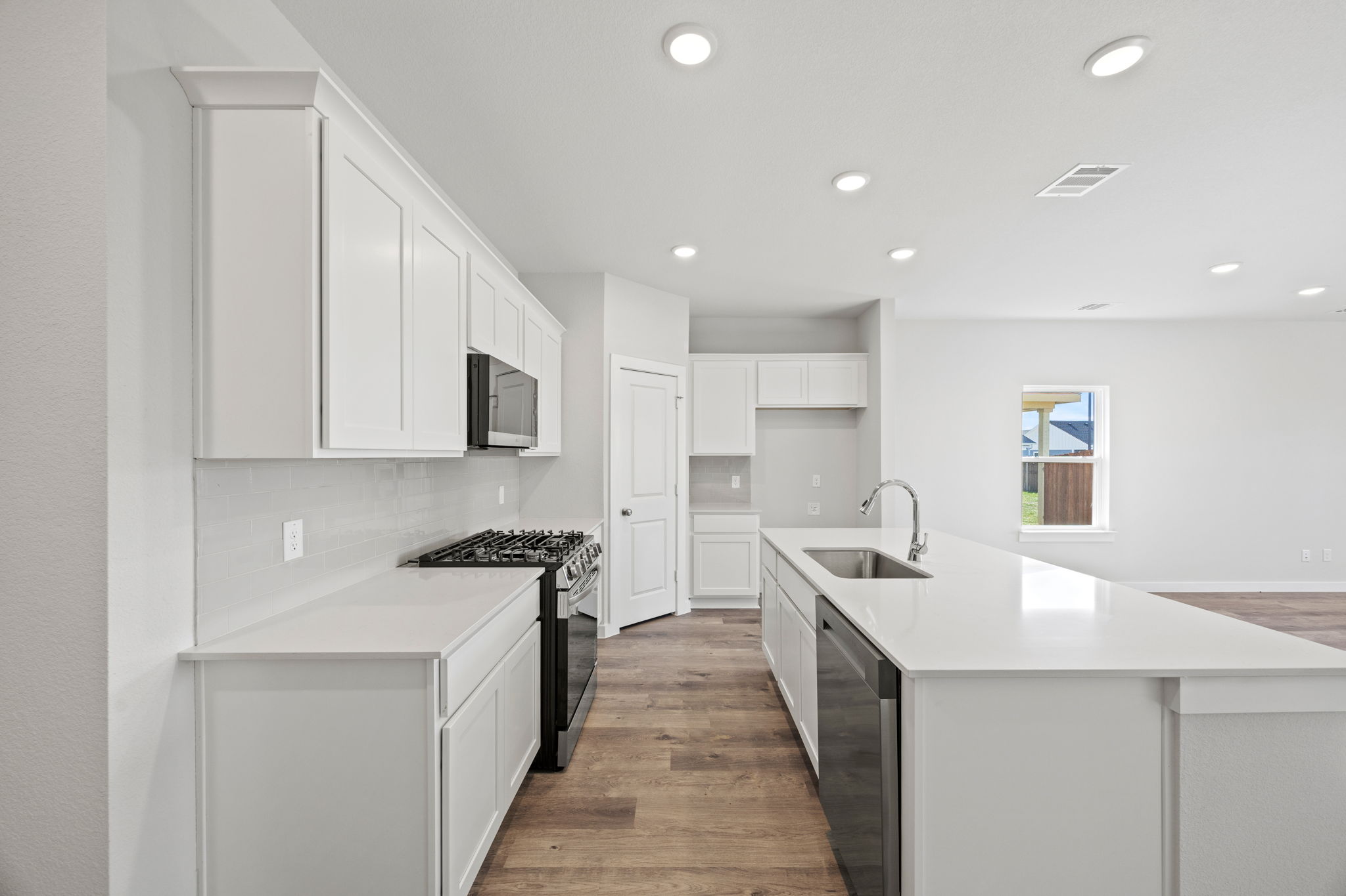 A kitchen with white cabinets.