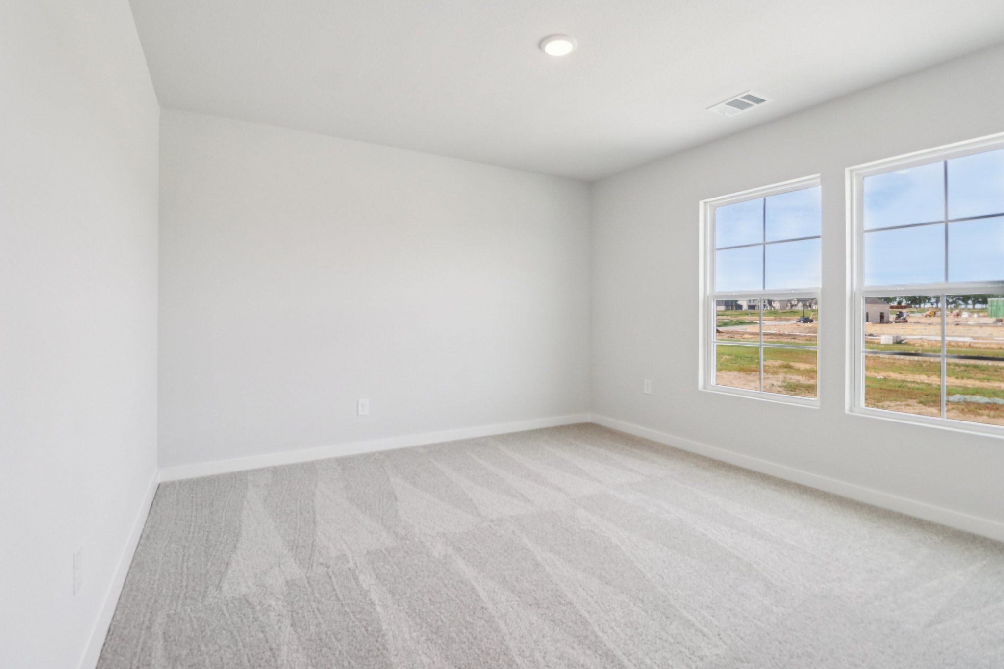 A room with windows and a carpet.