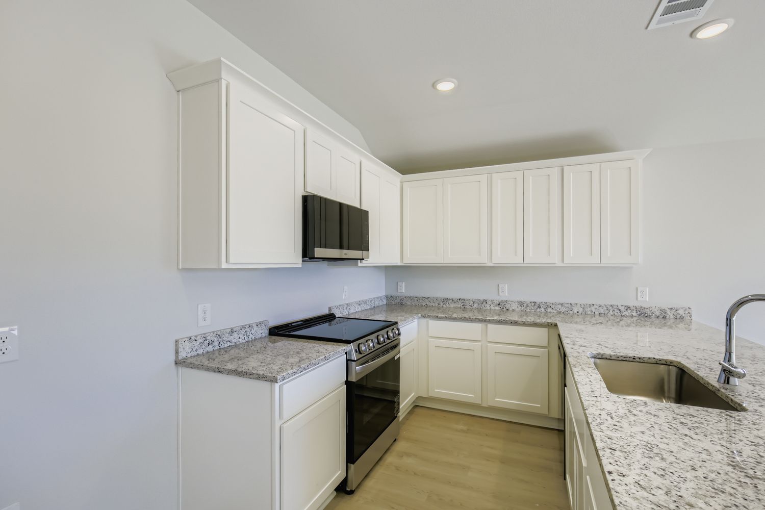 A kitchen with white cabinets.