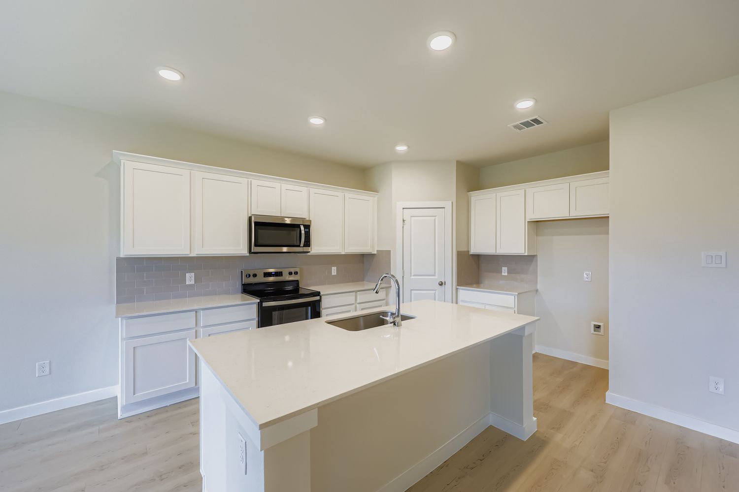 A kitchen with white cabinets.