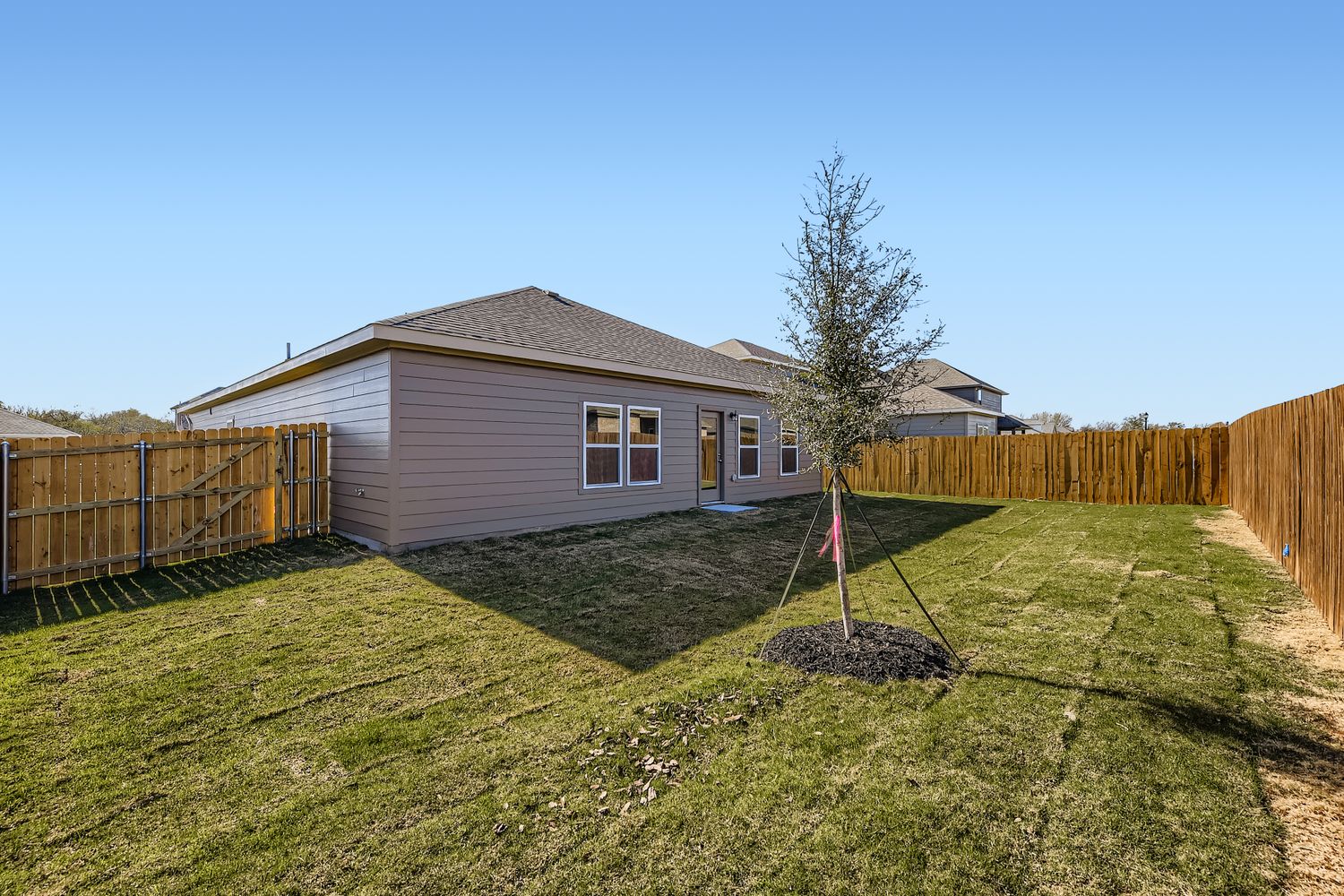 A small house with a fence and yard.