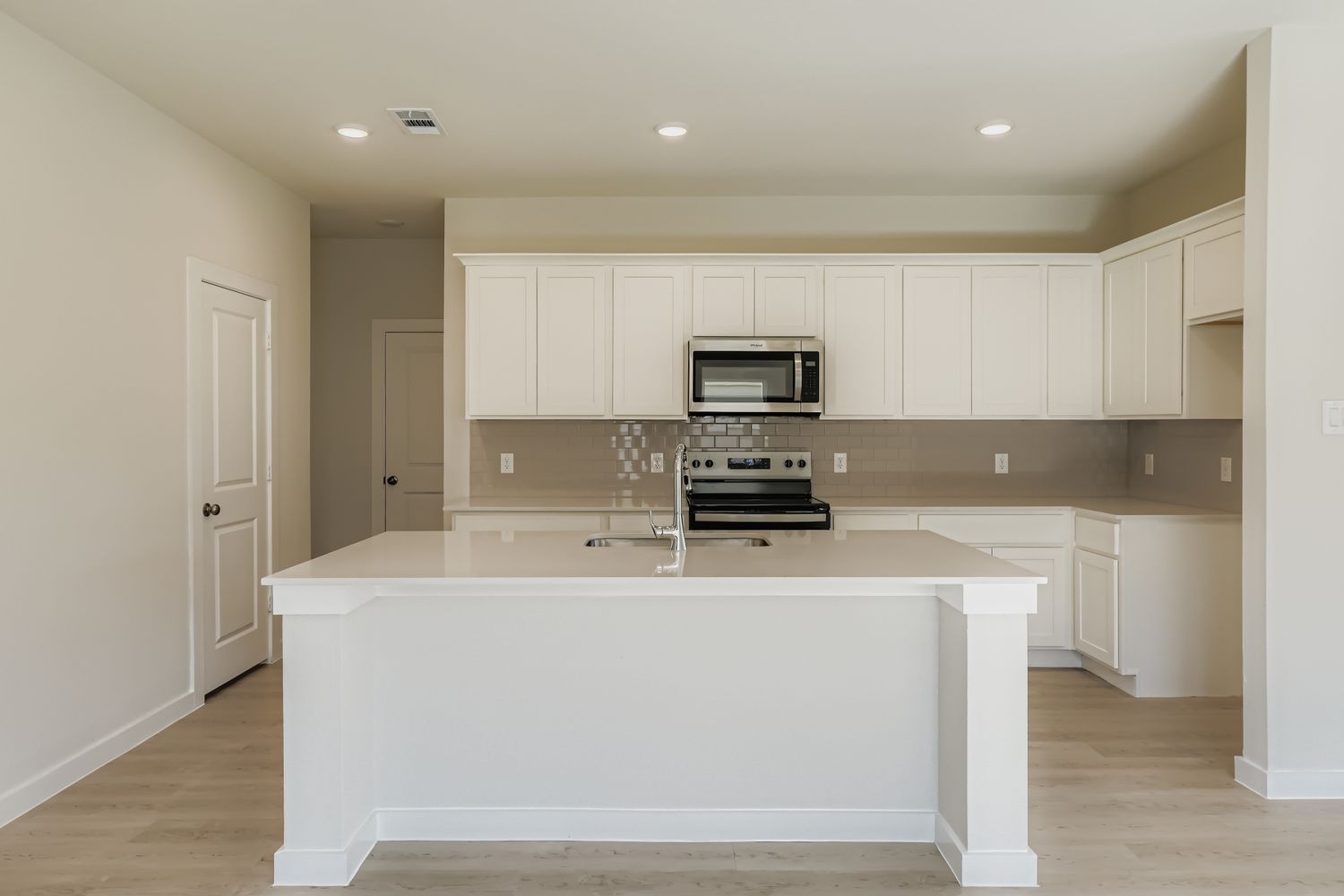 A kitchen with white cabinets.