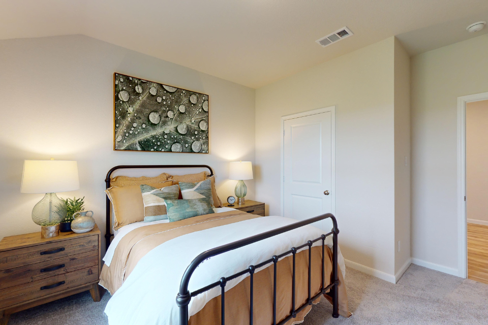 A bedroom with a bed and lamps.