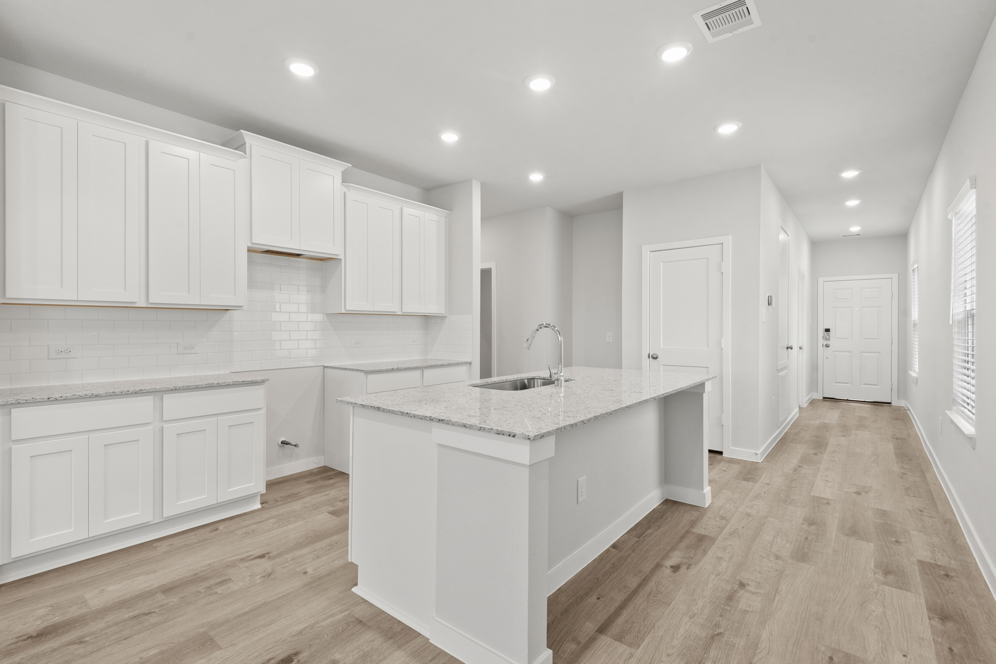 A kitchen with white cabinets.