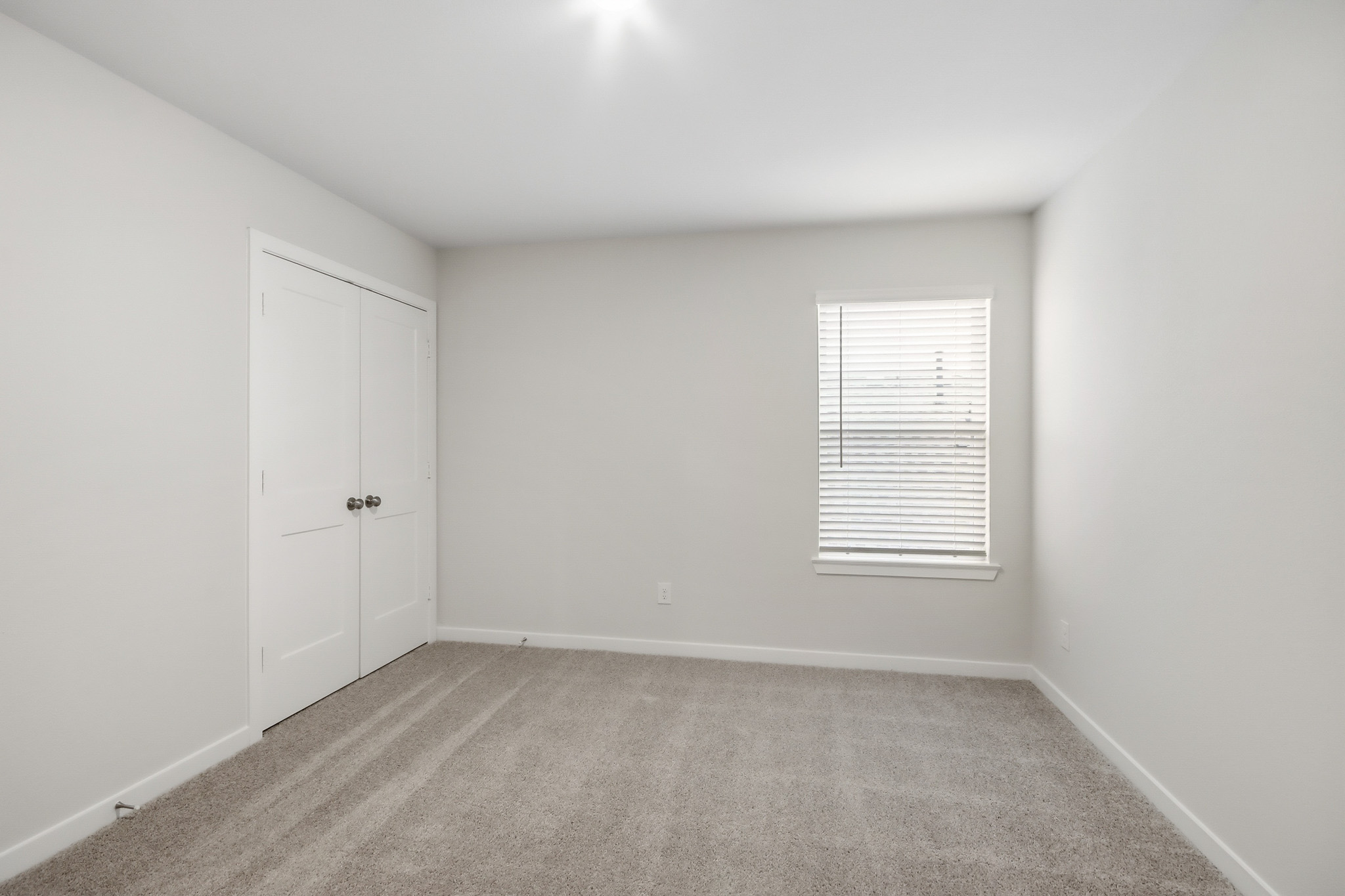 A room with white walls and a window.