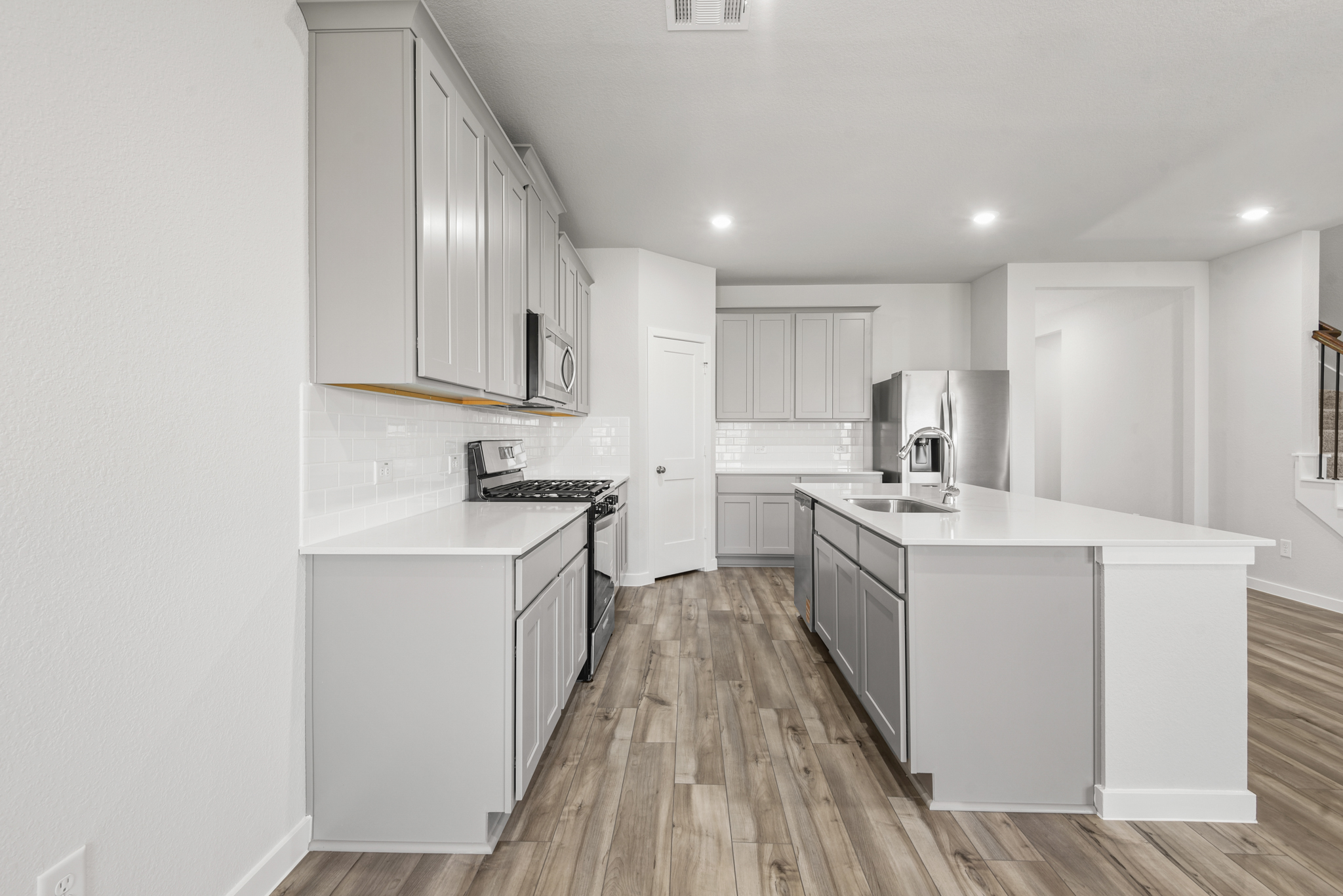 A kitchen with white cabinets.