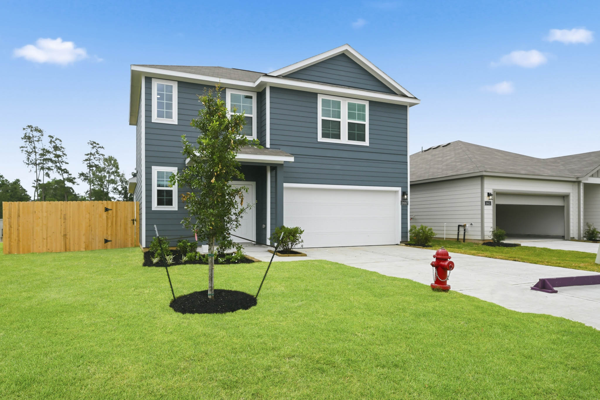 A house with a red fire hydrant in the front yard.