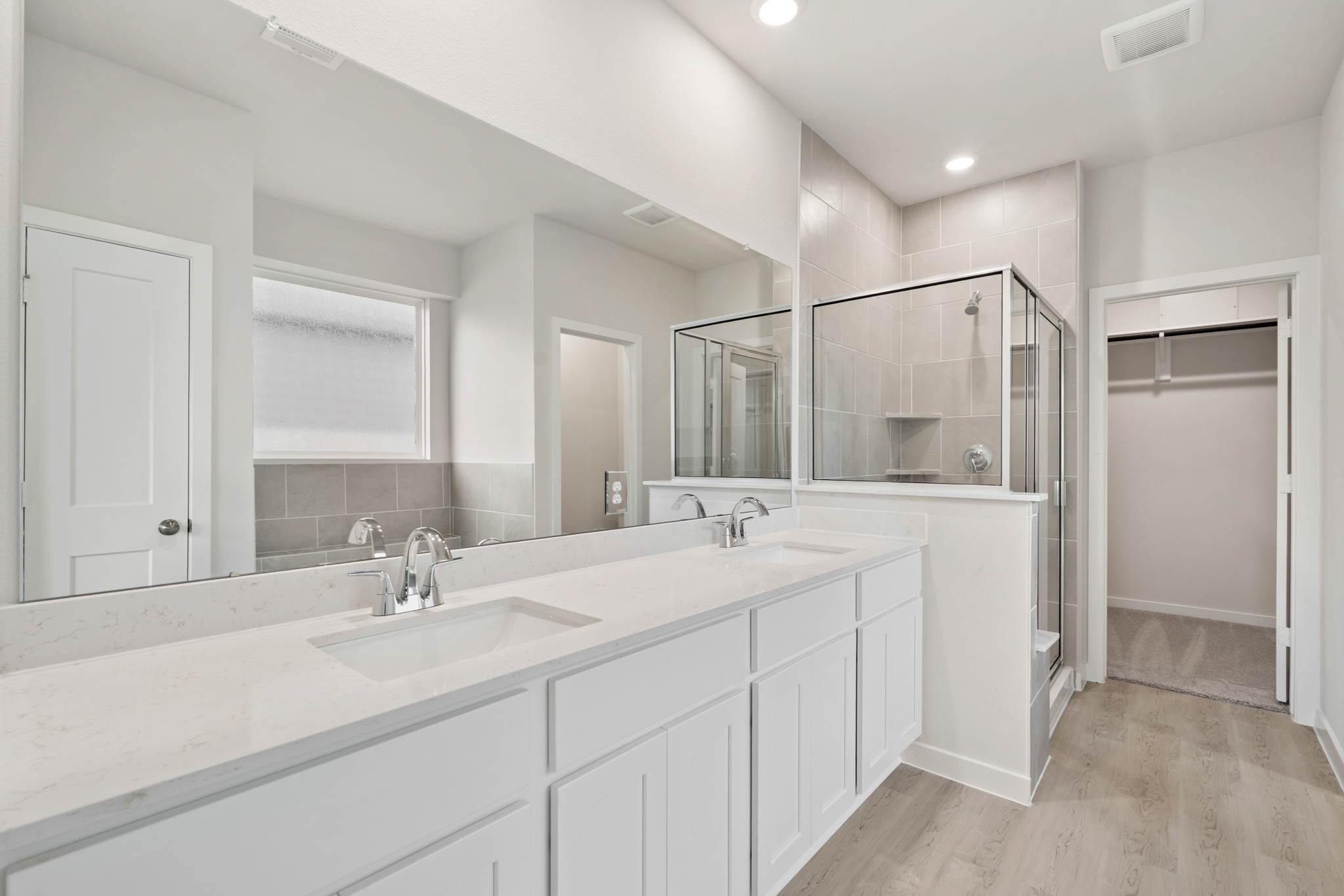 A bathroom with white cabinets.