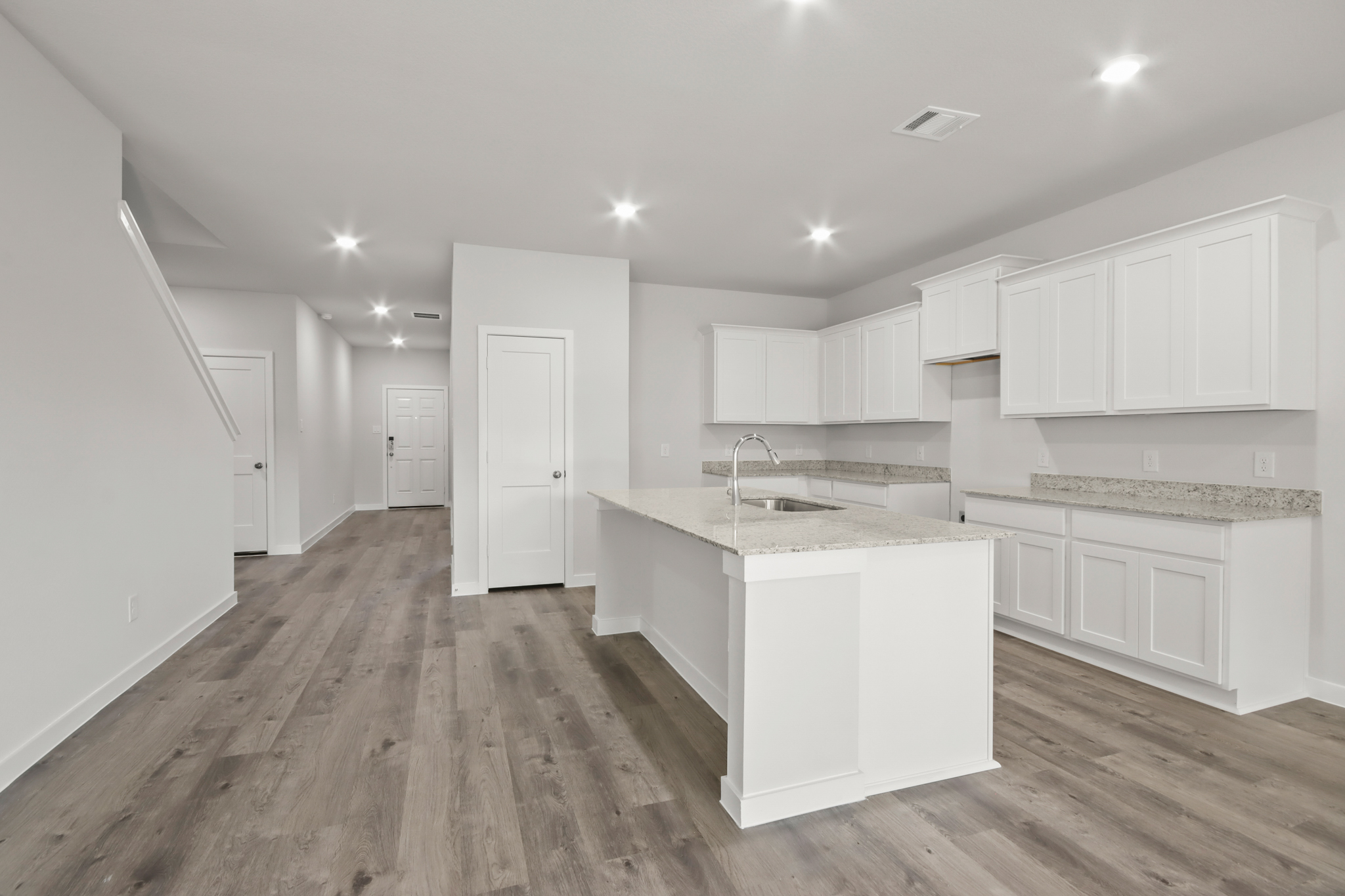 A kitchen with white cabinets.