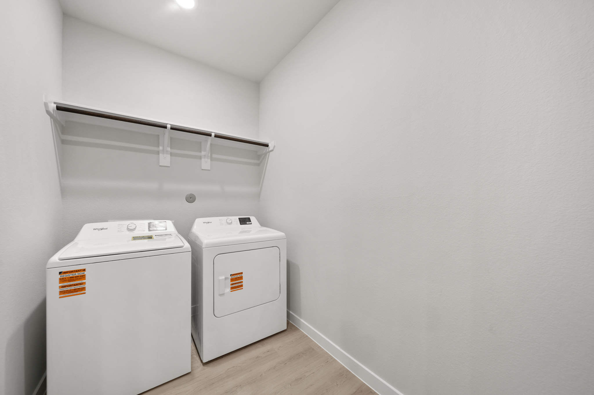 A white wall with a white machine and a white shelf.