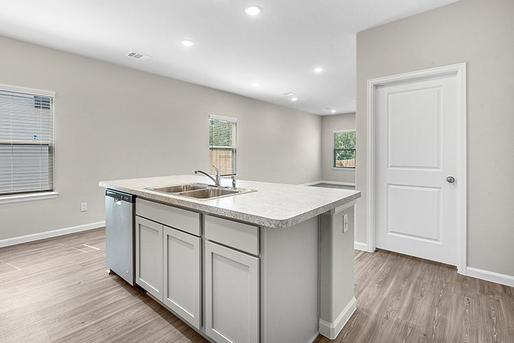 A kitchen with white cabinets.