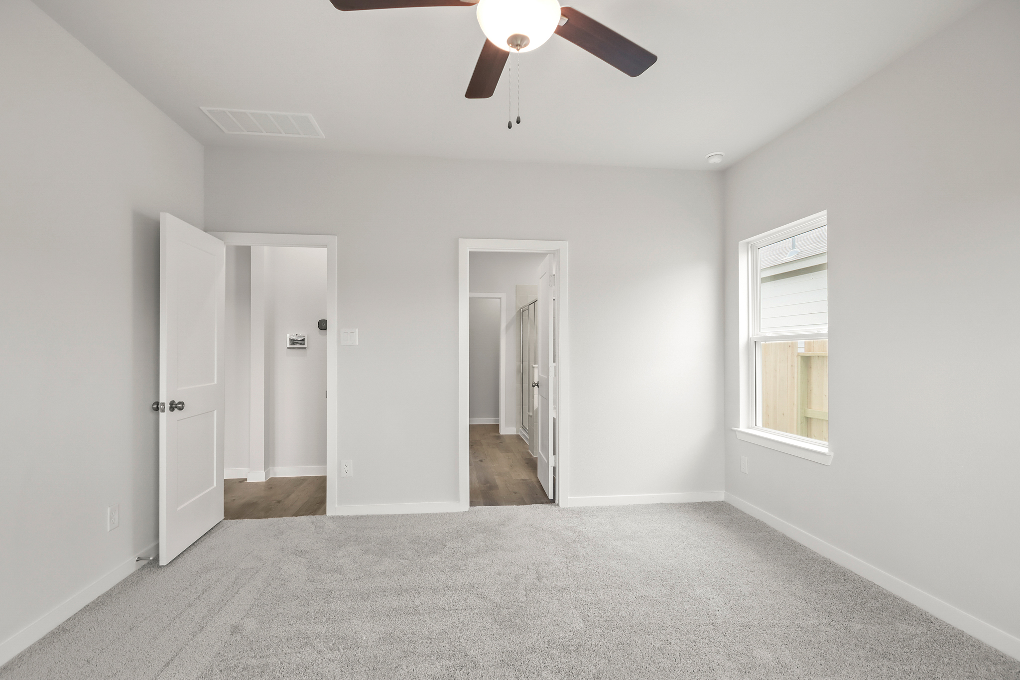 A room with white walls and a ceiling fan.