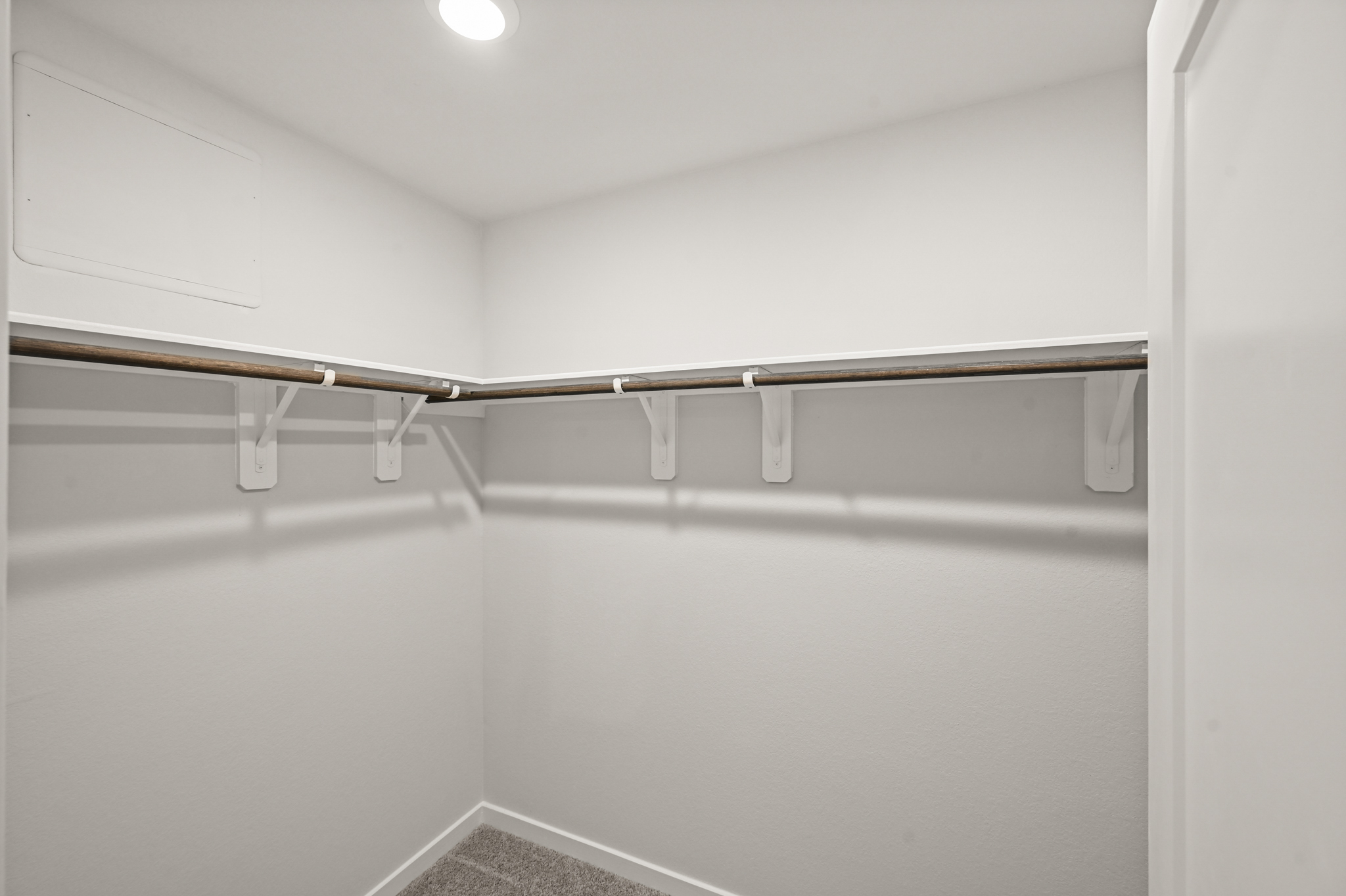 A white wall with a metal bar.