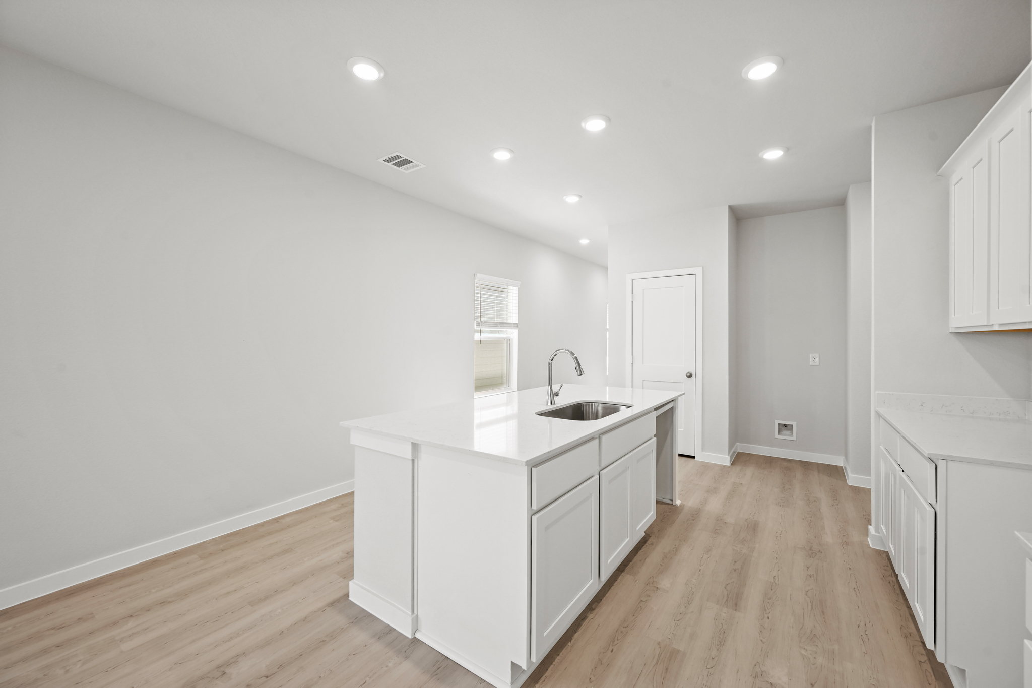 A kitchen with white cabinets.