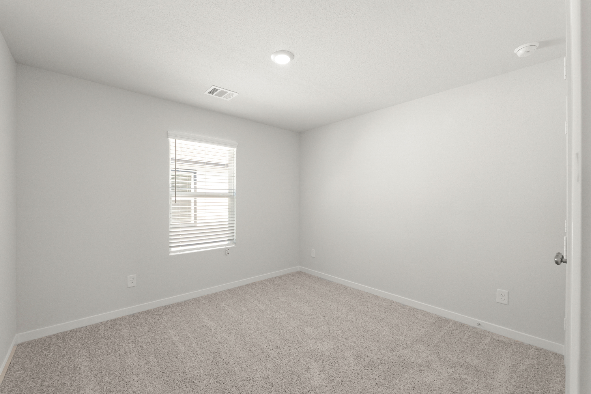 A room with a carpet and a window.