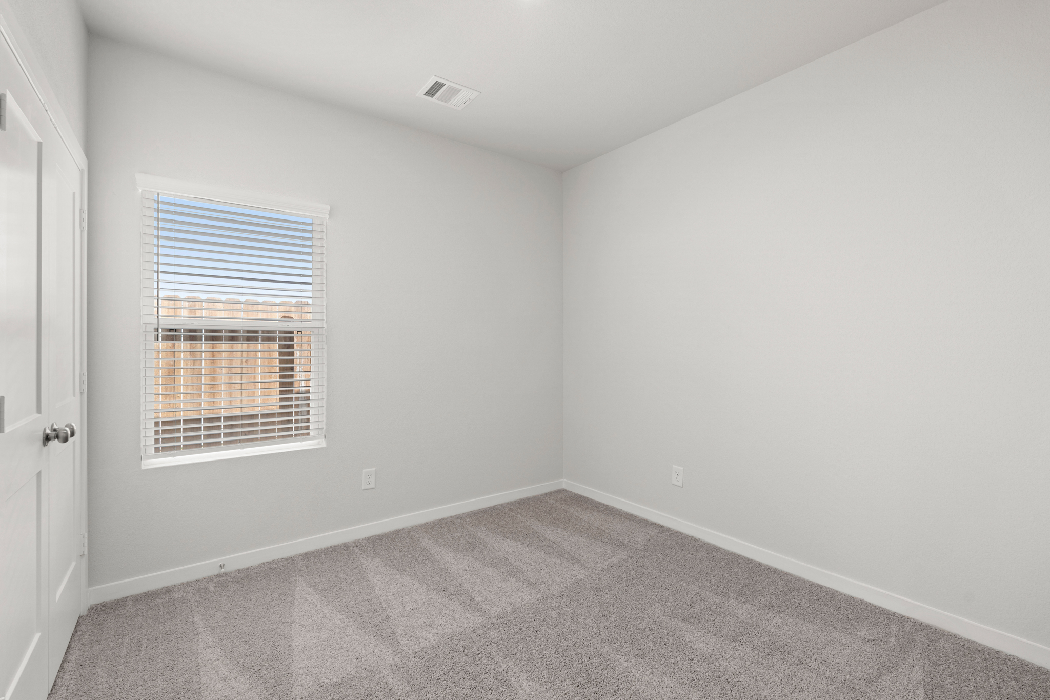 A room with a window and a carpet.