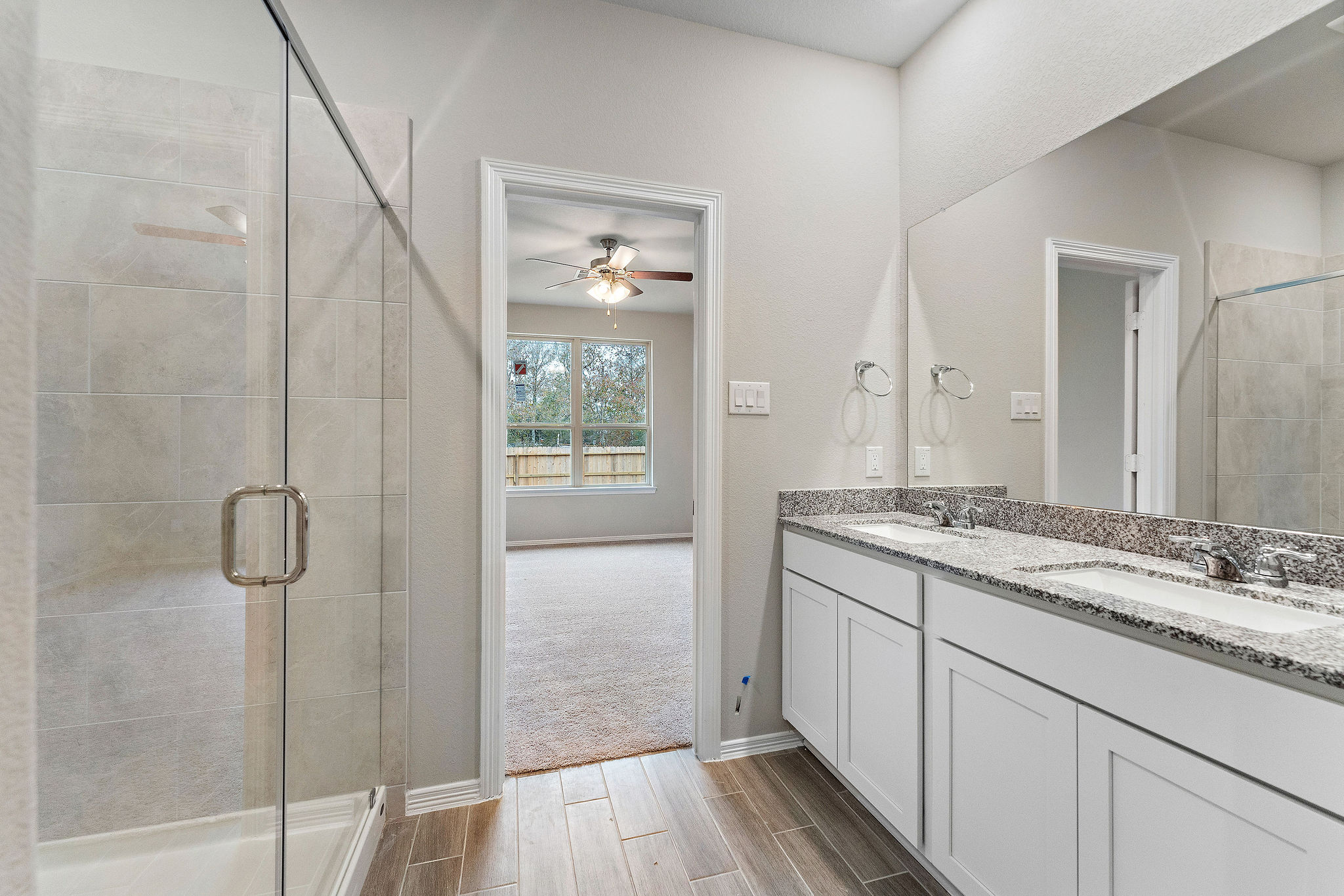 A bathroom with a shower unit and a glass door.