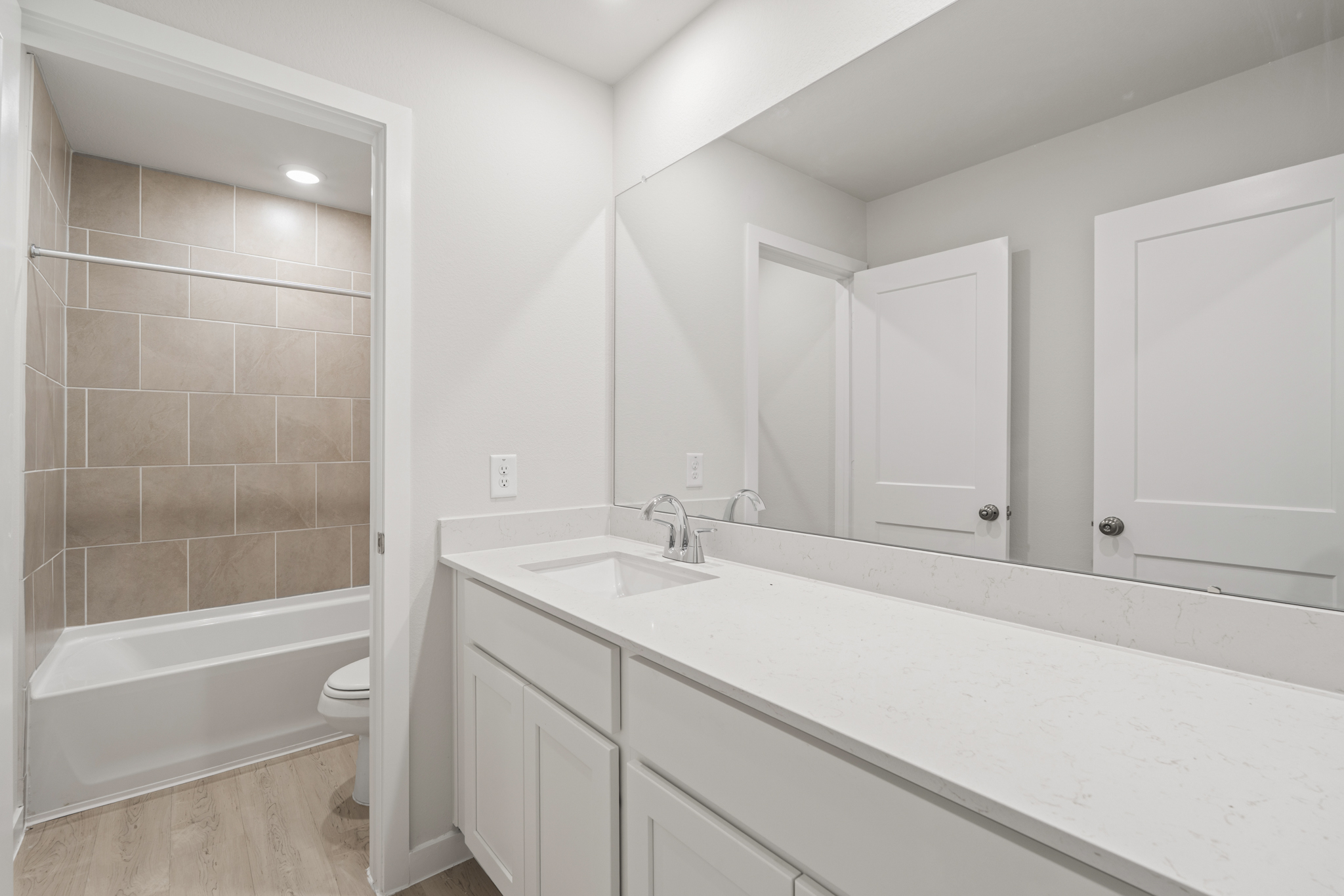 A bathroom with a tub sink and toilet.