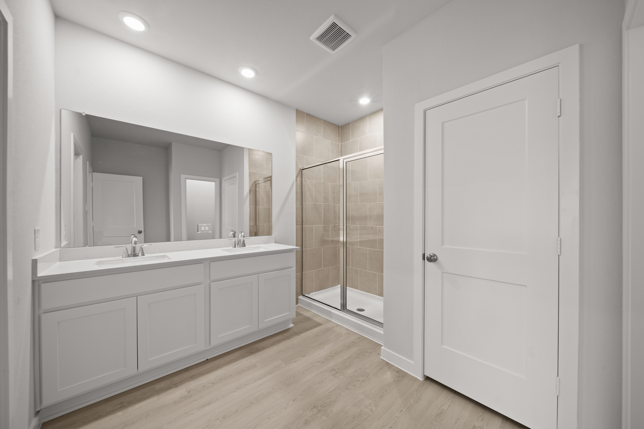 A bathroom with white cabinets.