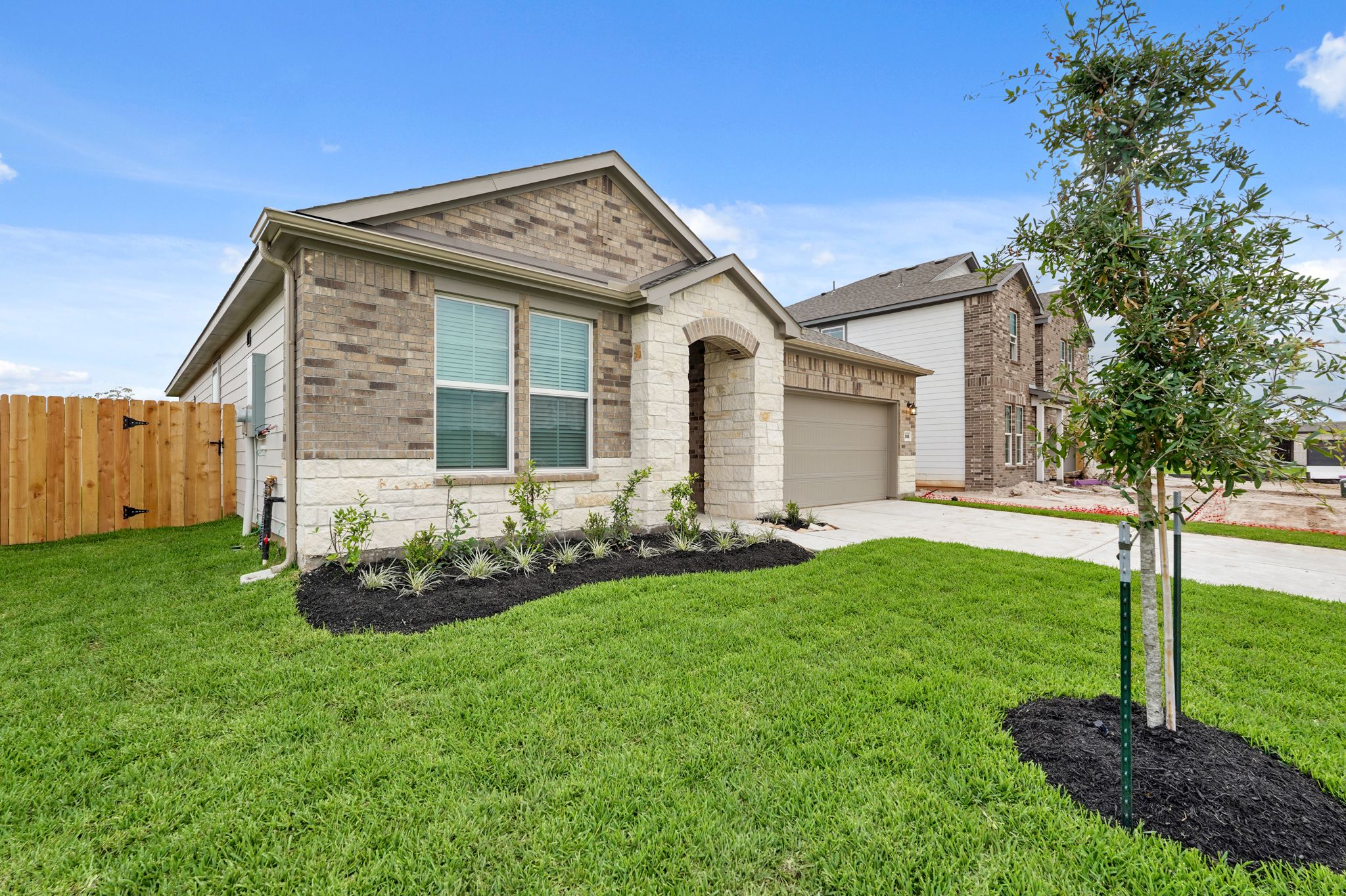 A house with a fence and a yard with a tree.