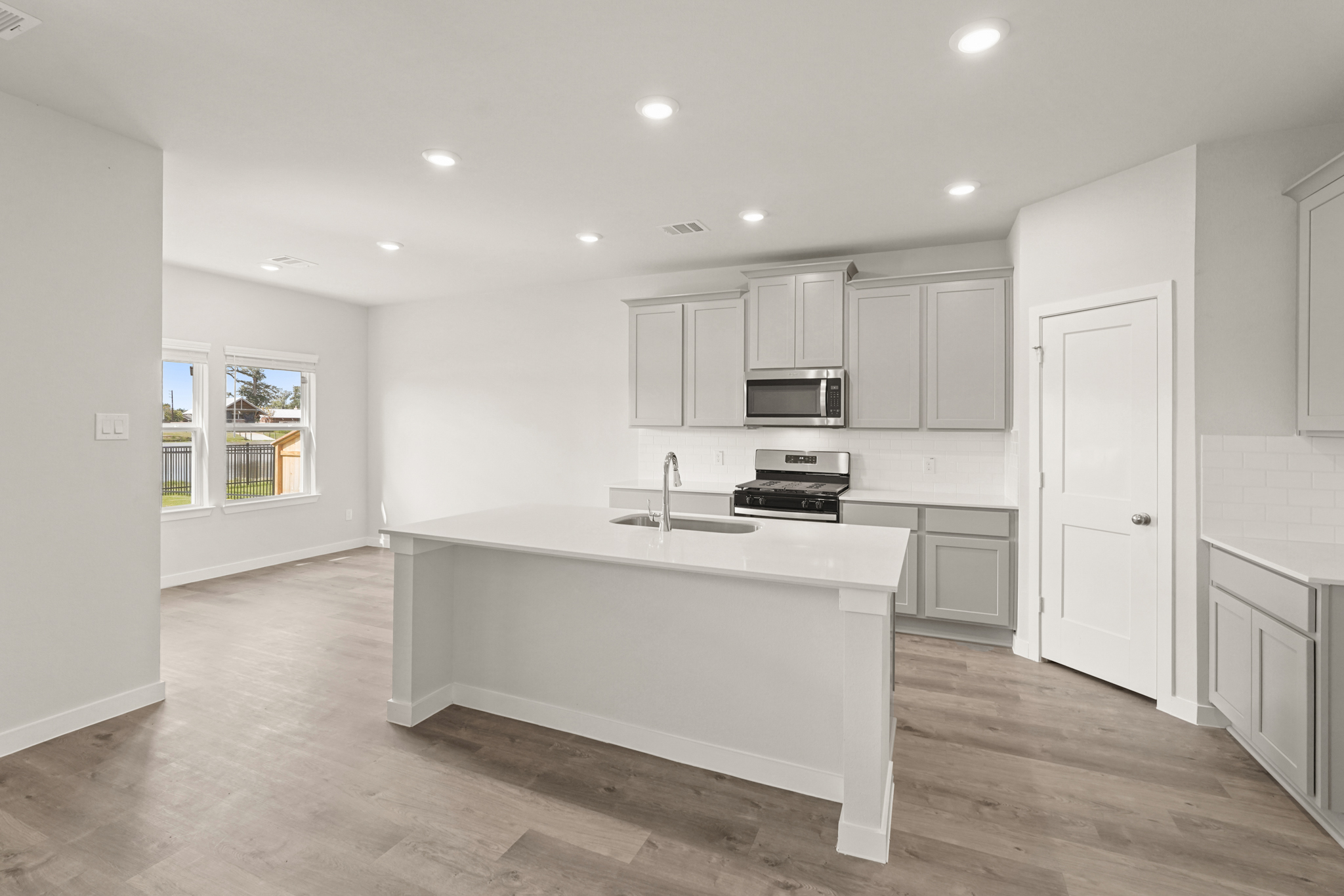 A kitchen with white cabinets.