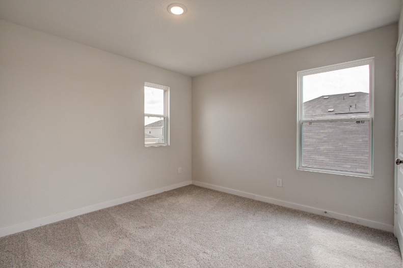 A room with a window and a carpet.