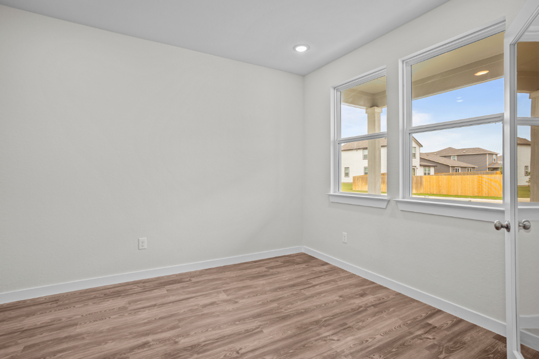 A room with a wood floor and a window with a wood floor.