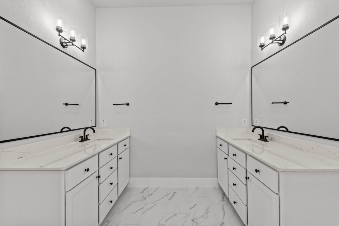 A bathroom with white cabinets.