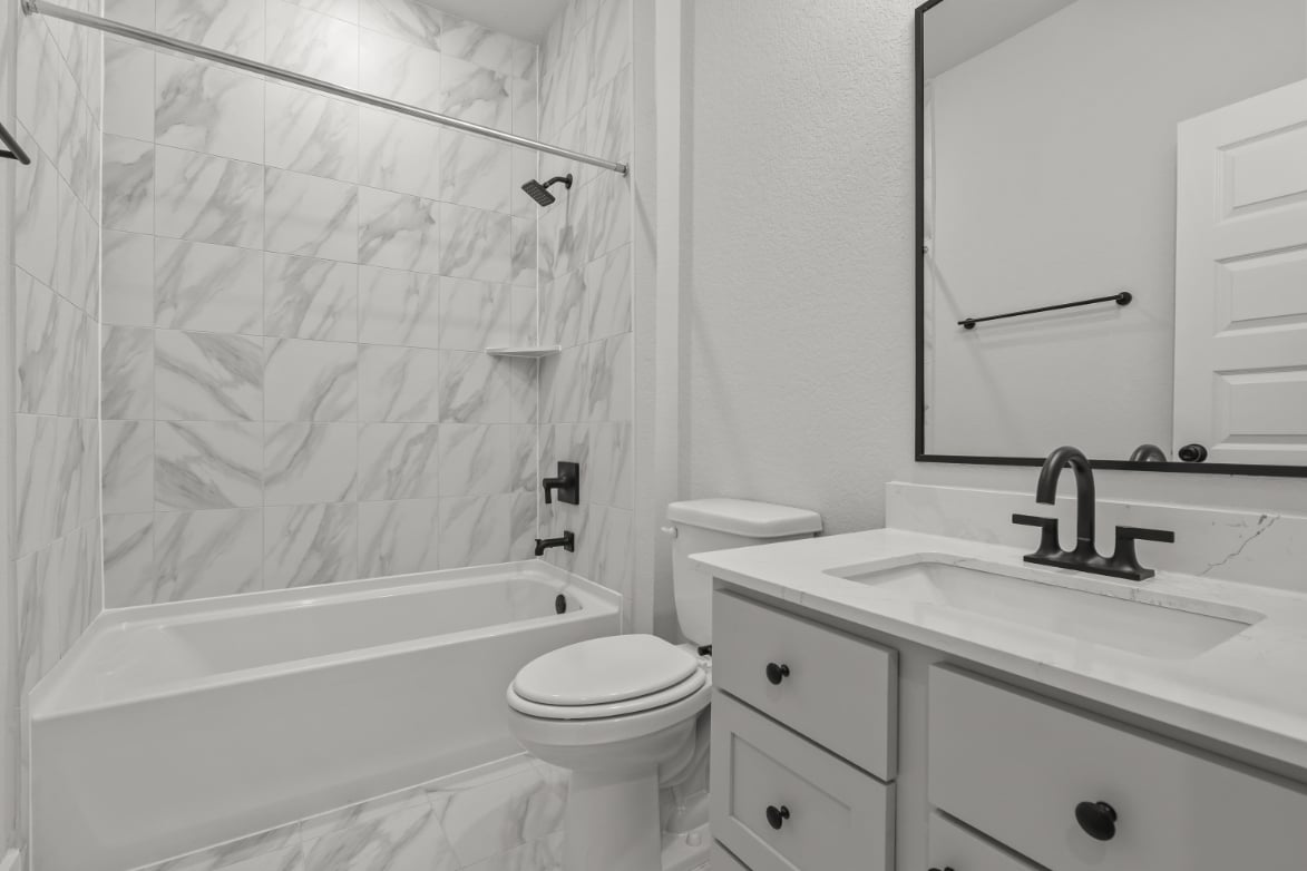 A bathroom with a tub sink and toilet.