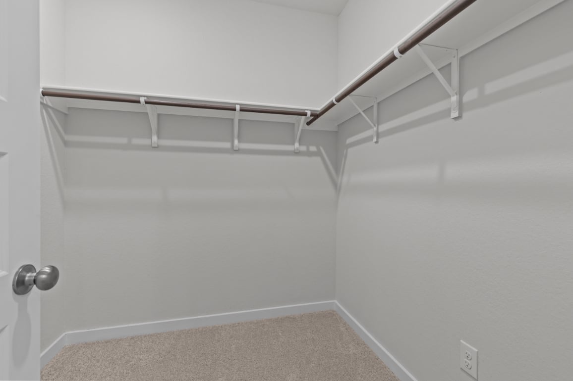 A white wall with a metal bar.