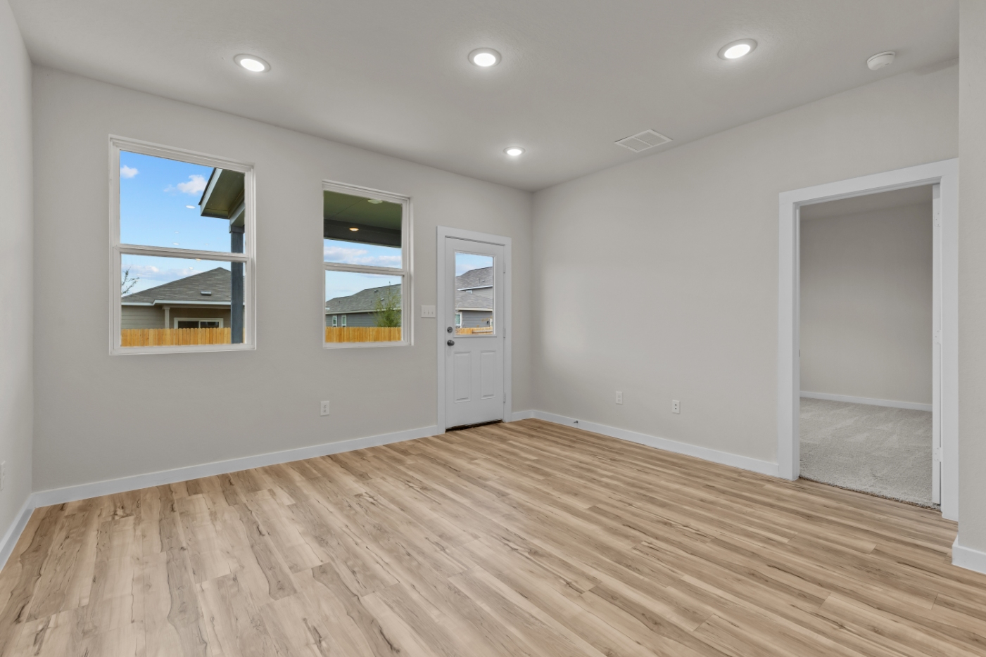 A room with a wood floor and a wood floor with a window.