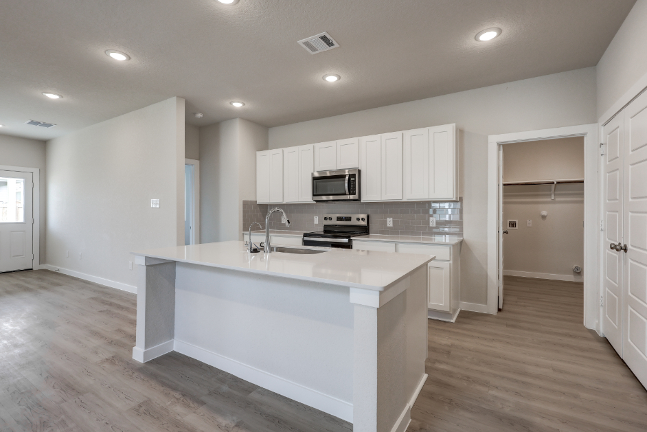 A kitchen with white cabinets.