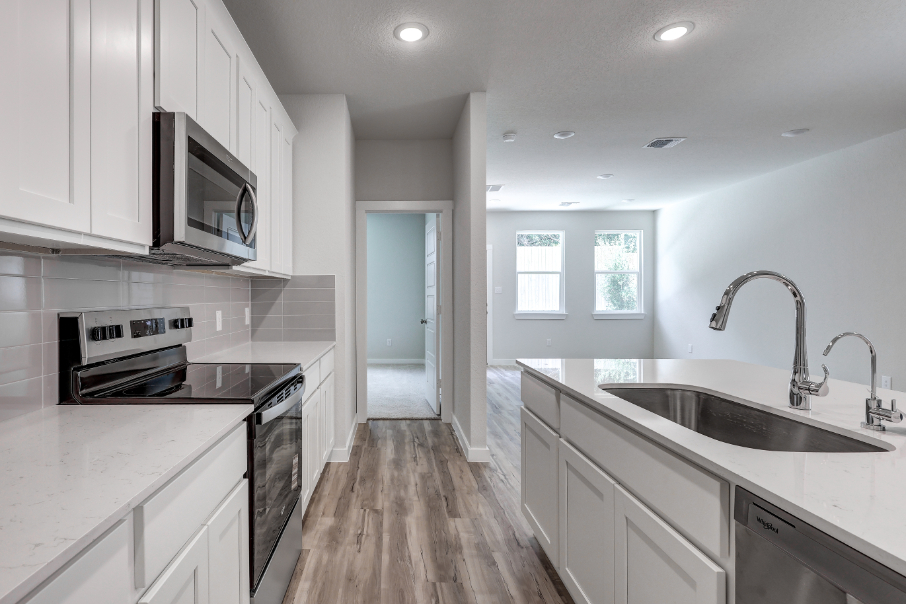 A kitchen with white cabinets.