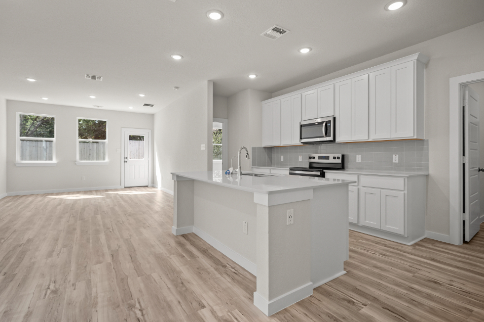 A kitchen with white cabinets.
