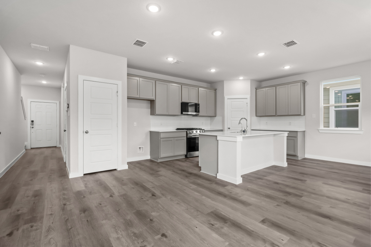 A kitchen with white cabinets.