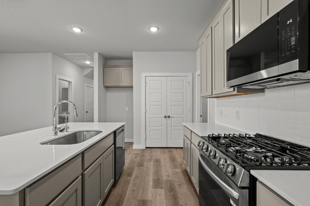 A kitchen with white cabinets.