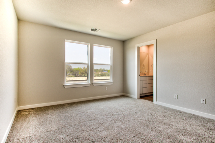 A room with a window and a carpet.