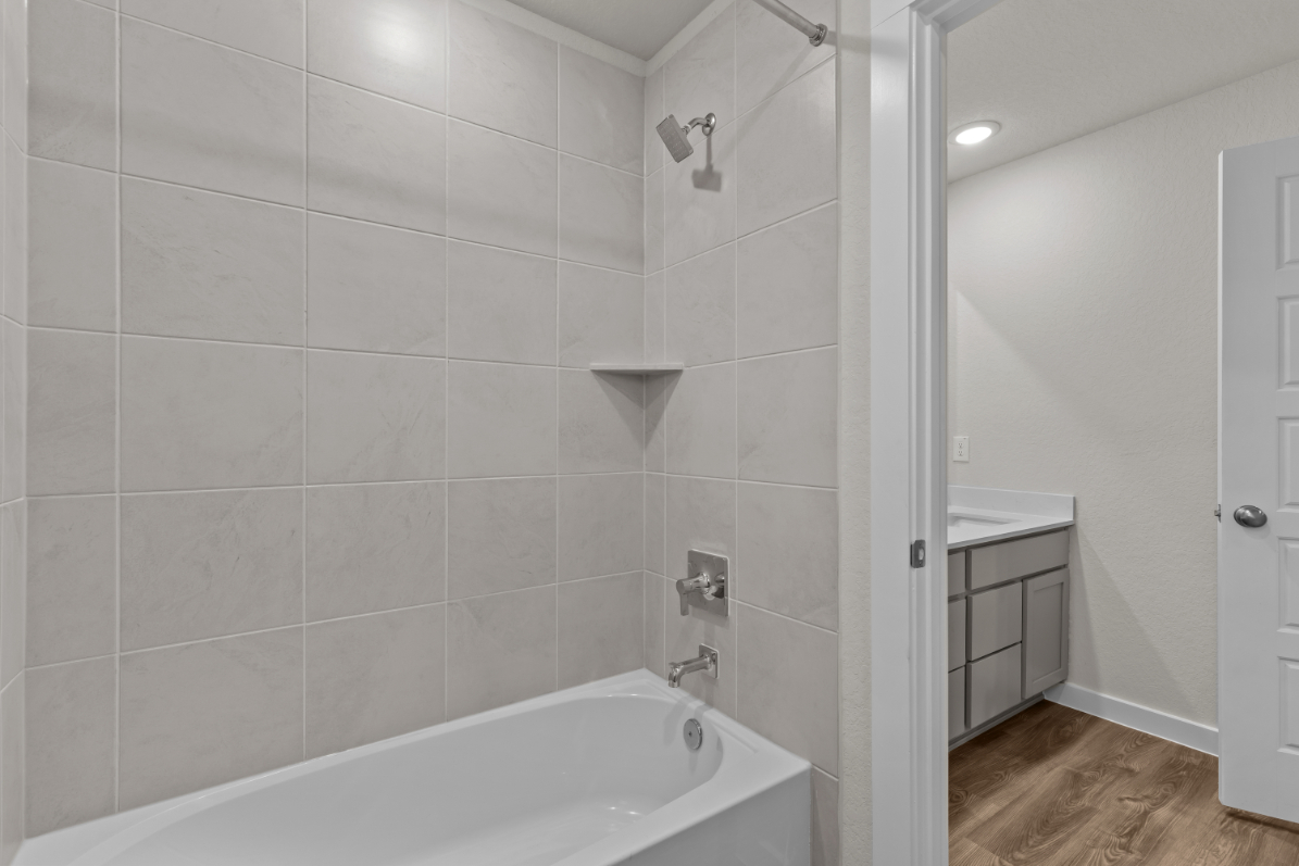 A bathroom with a bathtub and shower.