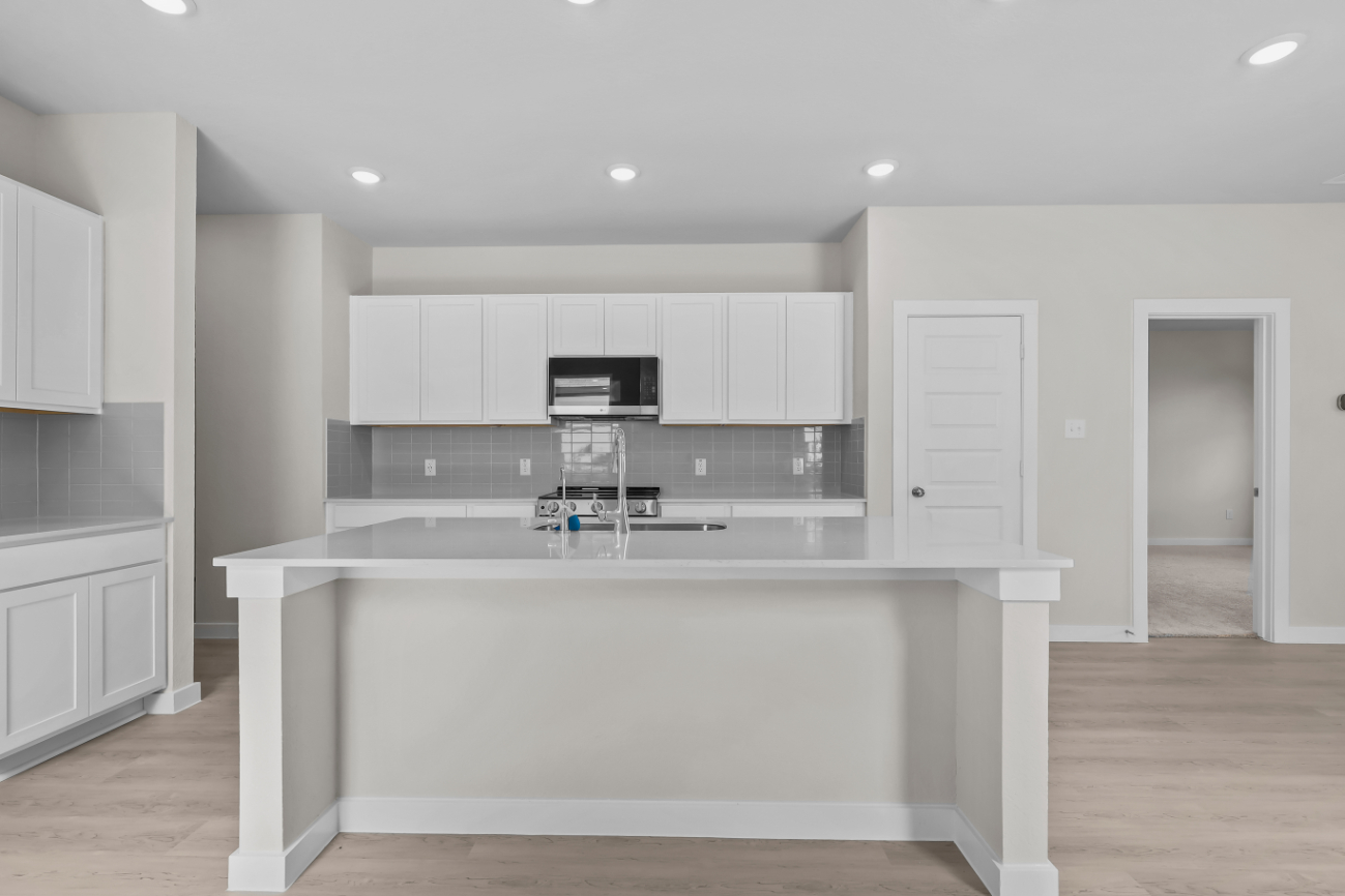 A kitchen with white cabinets.
