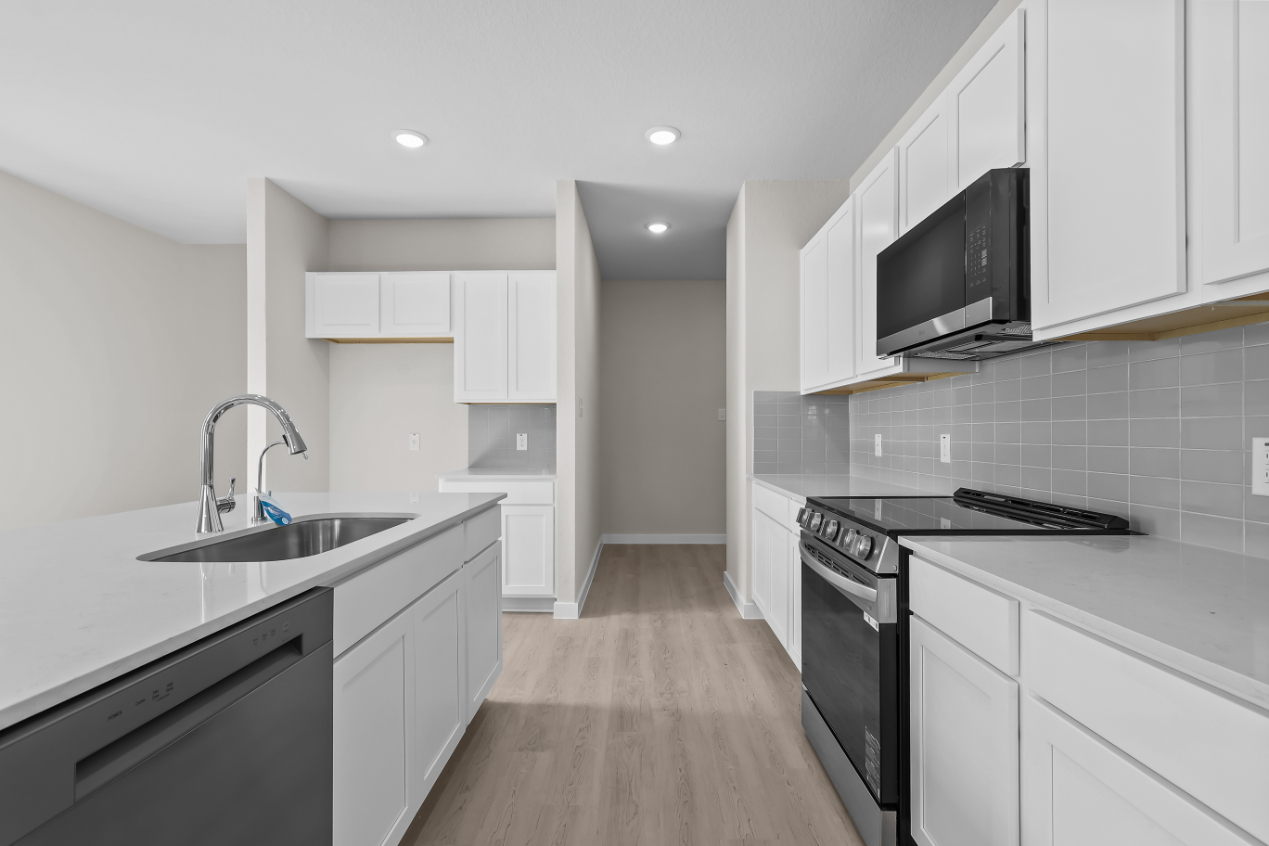 A kitchen with white cabinets.