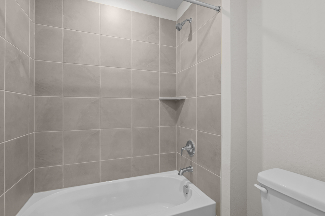A bathtub and toilet in a bathroom.