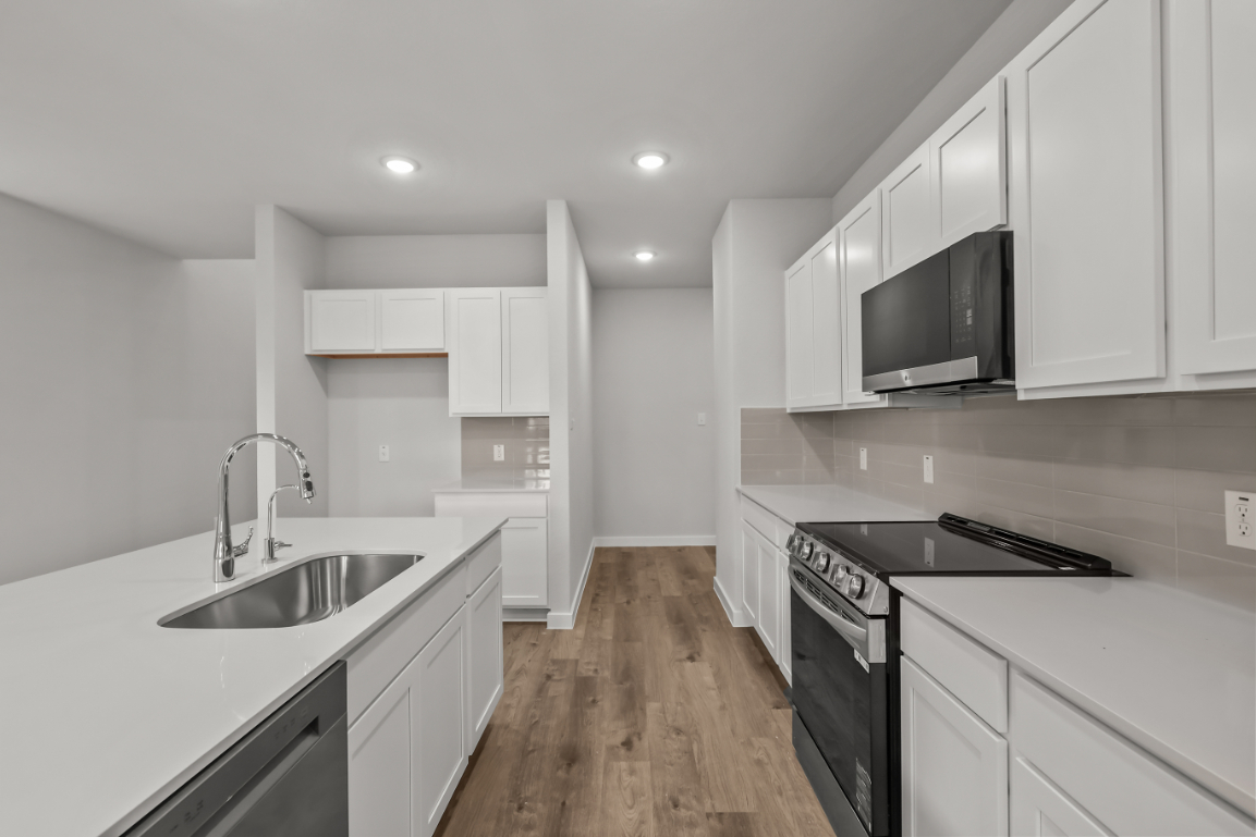 A kitchen with white cabinets.